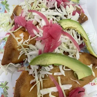 a plate of fish topped with avocado and slaw