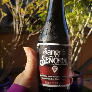 a person holding a bottle of beer