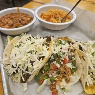 Brisket, beef + chicken tacos. Beans + rice