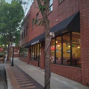 a tree in front of a restaurant