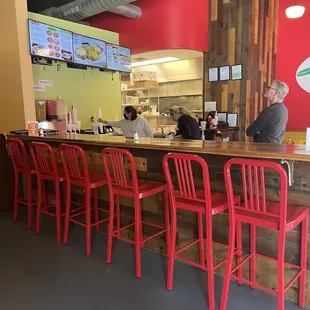 a bar with red chairs