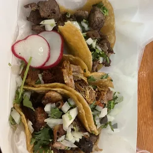 Tripa, carnitas, lengua tacos from bottom to top