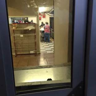 a person in a kitchen through a glass door
