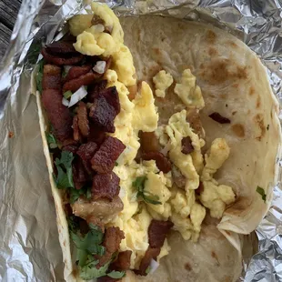 Bacon, egg, and potato breakfast "taco" with cilantro and onions