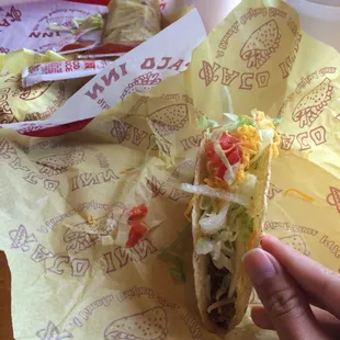 a hand holding a taco