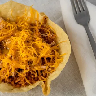 a taco with shredded cheese on top