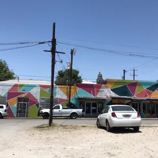 cars parked in front of a colorful building