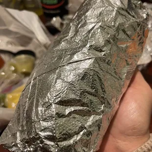 a hand holding a piece of foil wrapped in aluminum foil