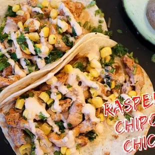 two chicken tacos on a plate with avocado