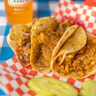three tacos on a checkered table cloth