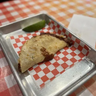 a taco sitting on a tray on a table
