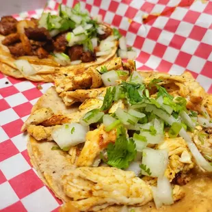 two tacos on a red and white checkered tray