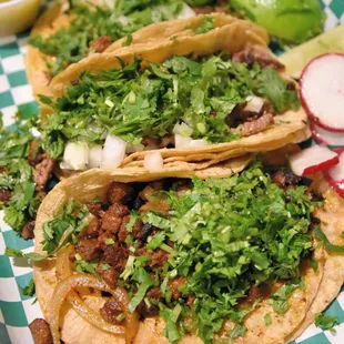 three tacos on a checkered tray