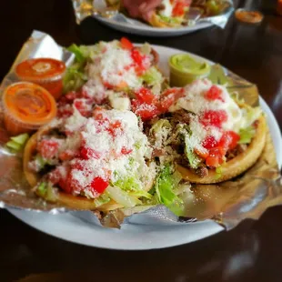 a plate of tacos with lettuce and tomatoes