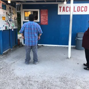 a man standing in front of a taco loco