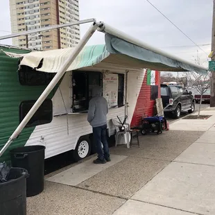 a man standing in front of a taco truck