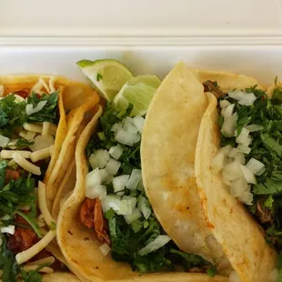 three tacos in a styrofoam container