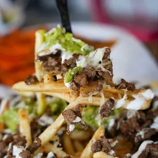 a plate of food with fries and guacamole