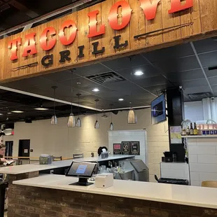 a restaurant counter with a sign above it