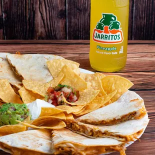 a plate of quesadillas and a bottle of soda