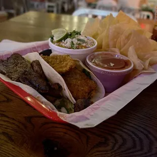 The whole deal, steak in front, fish then street corn and salsa/chips