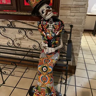 a skeleton sitting on a bench