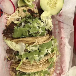 Barbacoa, carnitas, and lengua tacos with green sauce.
