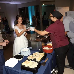 a bride and groom serving food to guests