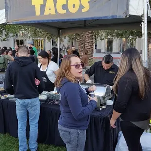 a group of people at a taco stand
