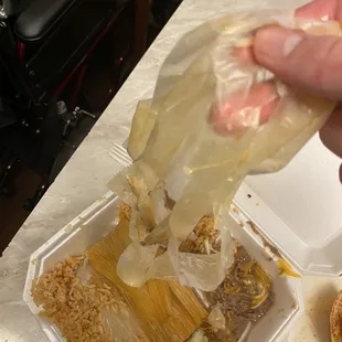 a hand holding a bag of taco