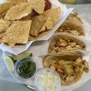 Chicken tacos with chips and salsa.
