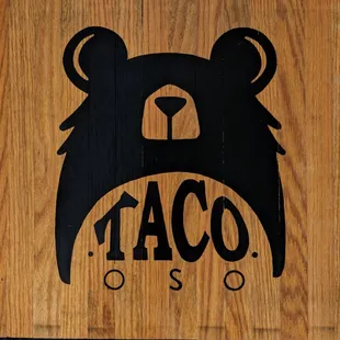 a taco bear on a wooden sign