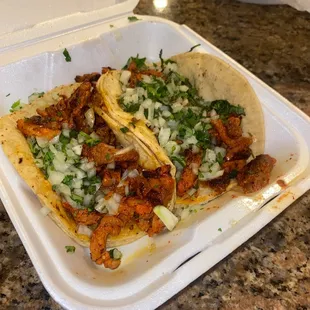 two tacos in a styrofoam container