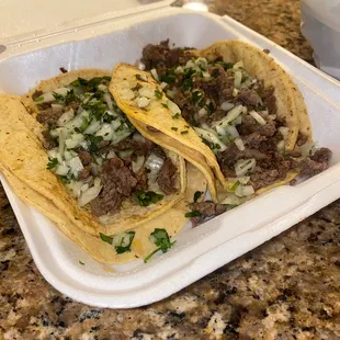 two tacos in a styrofoam container