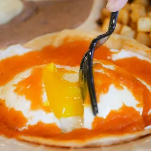 a person using a fork to pick up an egg