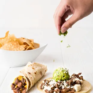 a hand sprinkling some tortilla