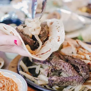 a hand holding a piece of meat