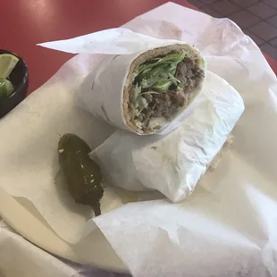 a burrito and pickles on a plate