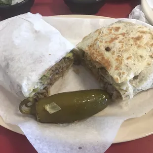 a burrito and a pickle on a plate