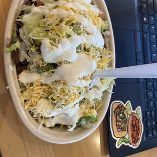 a bowl of taco salad and a laptop