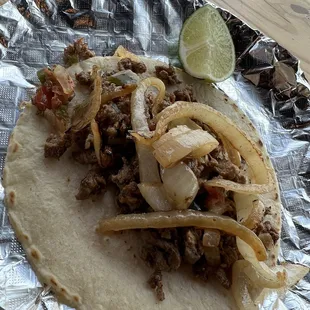a taco with meat and onions