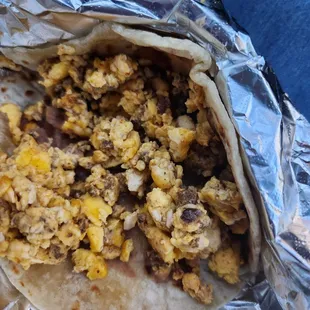 Breakfast taco of juevo con chorizo and some refried beans, flour tortilla.
