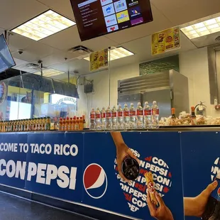 a man holding a donut in front of a counter