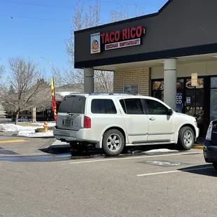 a white van parked in front of a taco rico restaurant