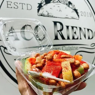 a hand holding a bowl of food