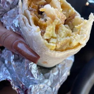 a hand holding a burrito