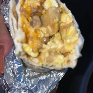 a hand holding a burrito
