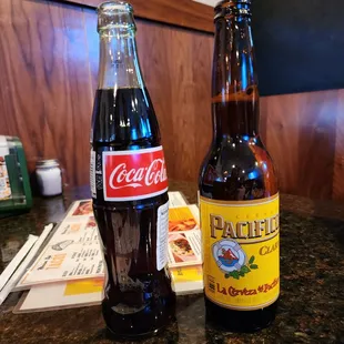 two bottles of coke and a bottle of soda