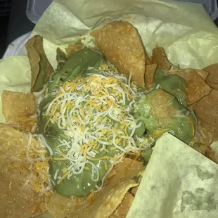 Chips and guac ordered via delivery. Apparently you have to specify no cheese and guacamole ON THE SIDE. This goes in the trash.