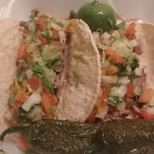 a plate of tacos and a pickle